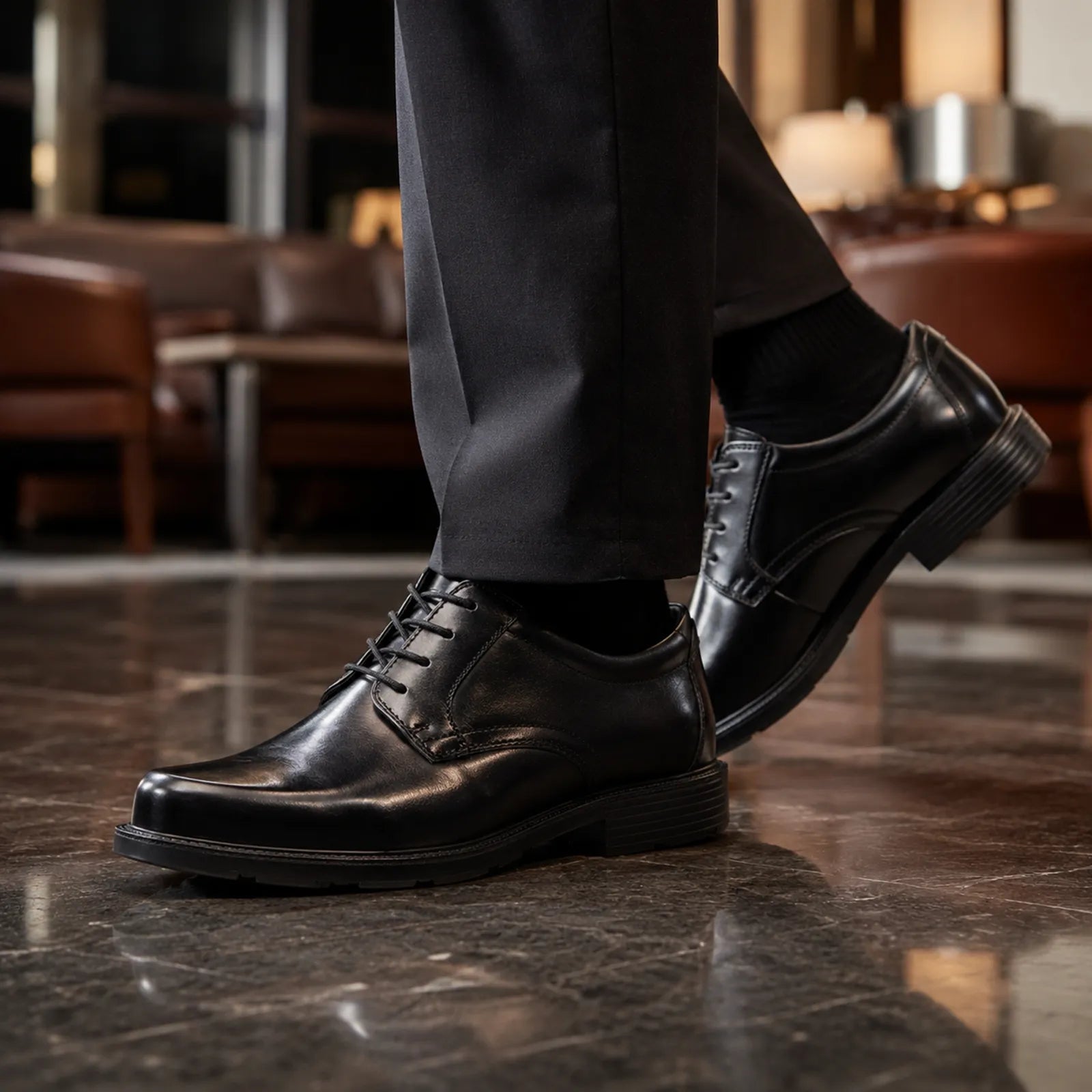 Black leather lace-up business shoe with chunky sole, close-up on foot