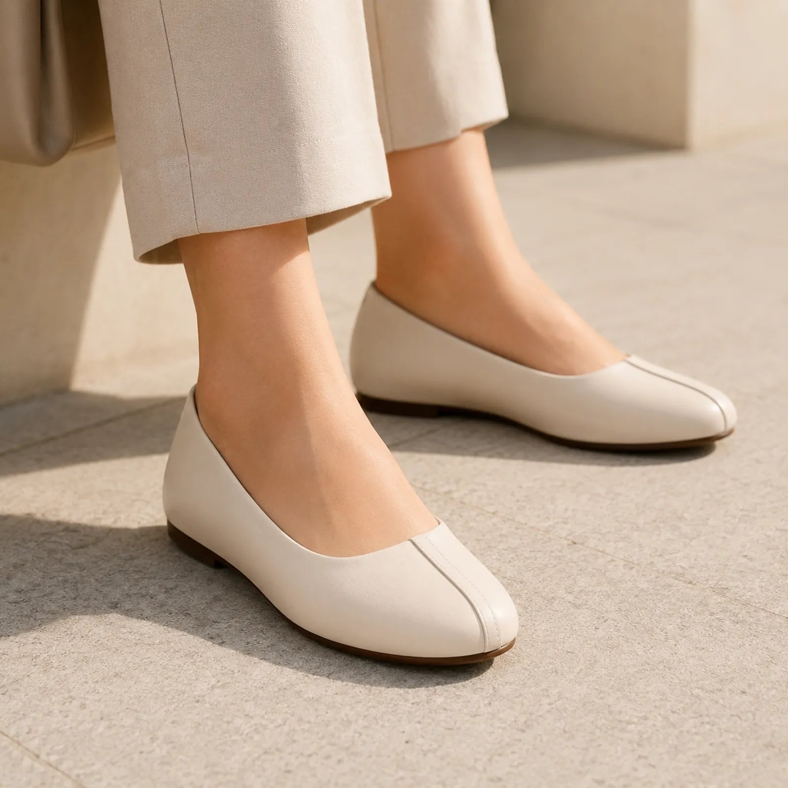 Cream leather low-heel pumps with simple seam detail and rounded toe