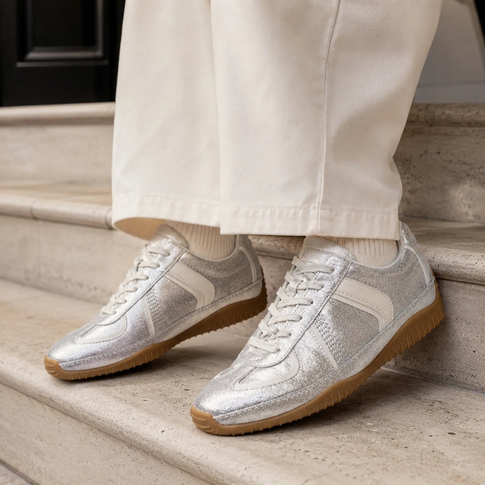 Pair of metallic silver lace-up sneakers with off-white panels and gum rubber soles