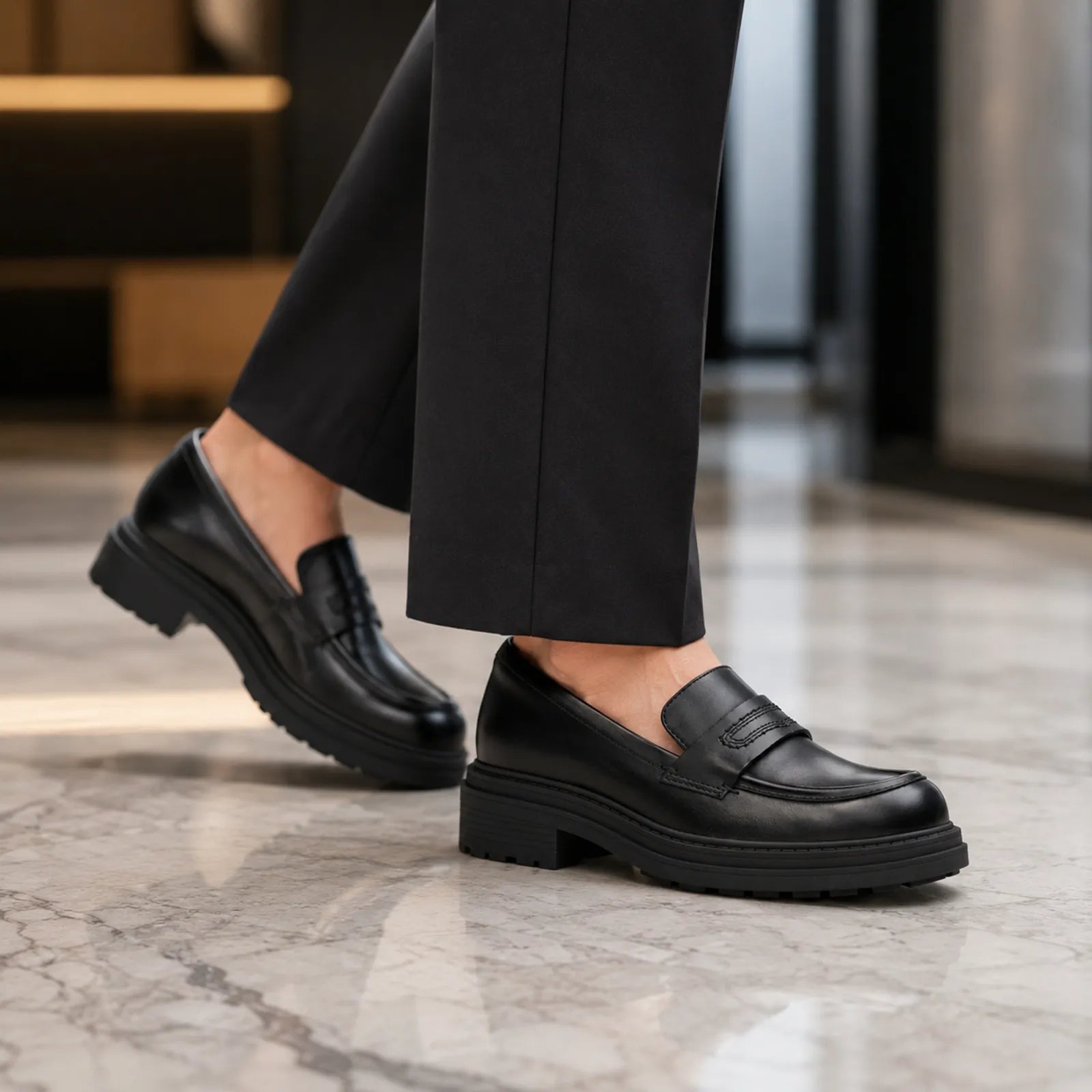 Black leather slip-on business shoes with block heel, worn with trousers