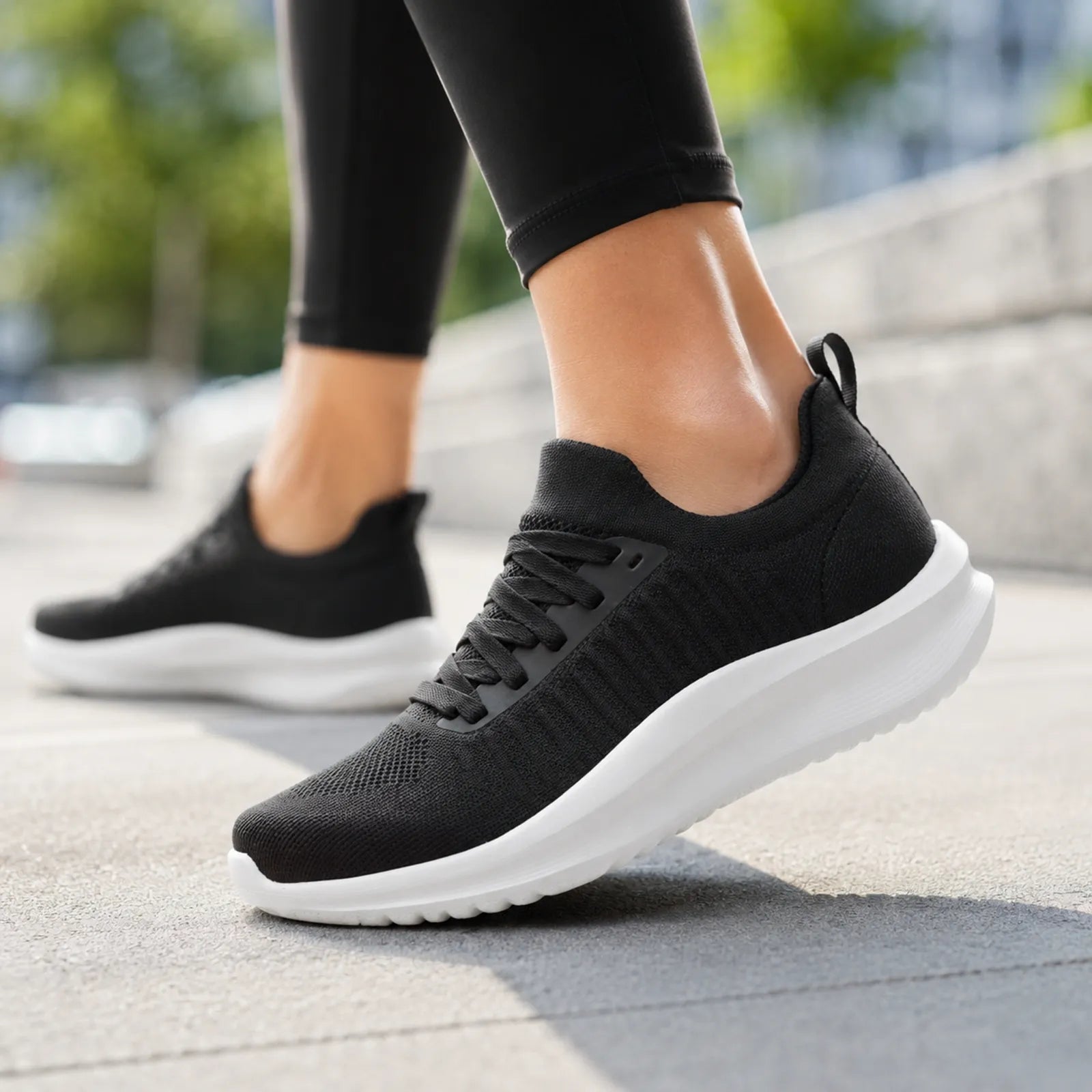 Black knit lace-up sneakers on standing legs with cushioned white sole