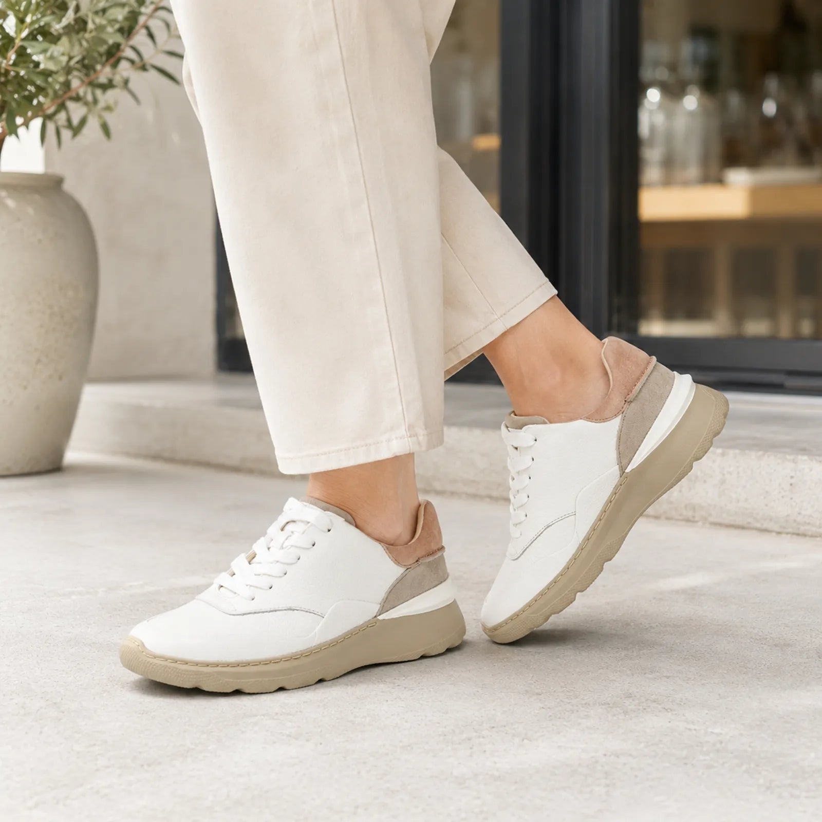 Women's white leather lace-up sneakers with beige outsole and cushioned sole unit