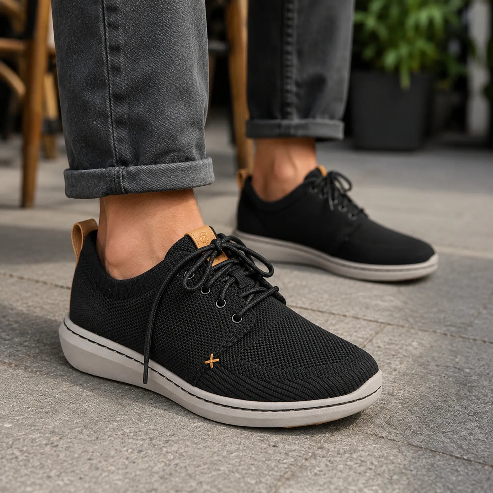 Black lace-up sneakers with textured knit upper, white midsole and rubber outsole