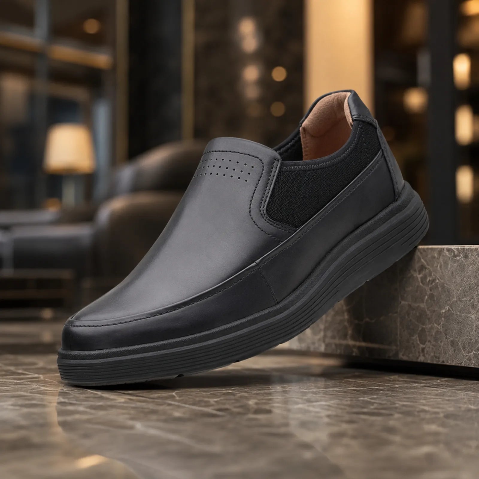 Black leather slip-on shoe with perforated toe panel and thick rubber sole