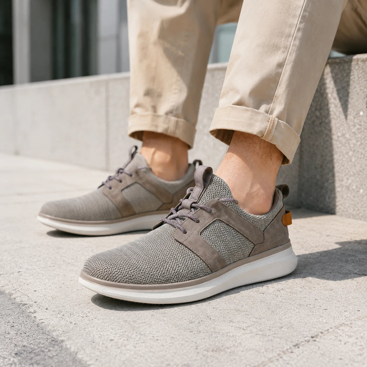Men's grey textile lace-up sneakers on feet, white rubber sole and dark lace panels