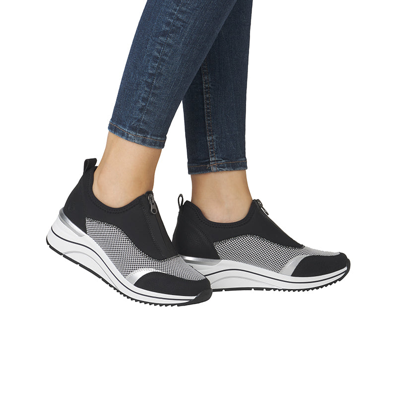 Women's black outdoor sneakers with mesh sides and white striped sole, on feet