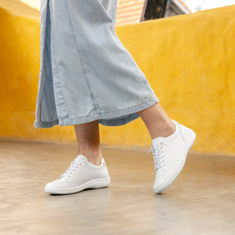 White lace-up sneakers worn with light blue cropped jeans