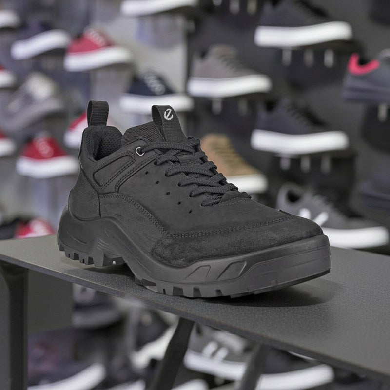 Men's black leather trail sneakers on display shelf, lace-up and lug sole