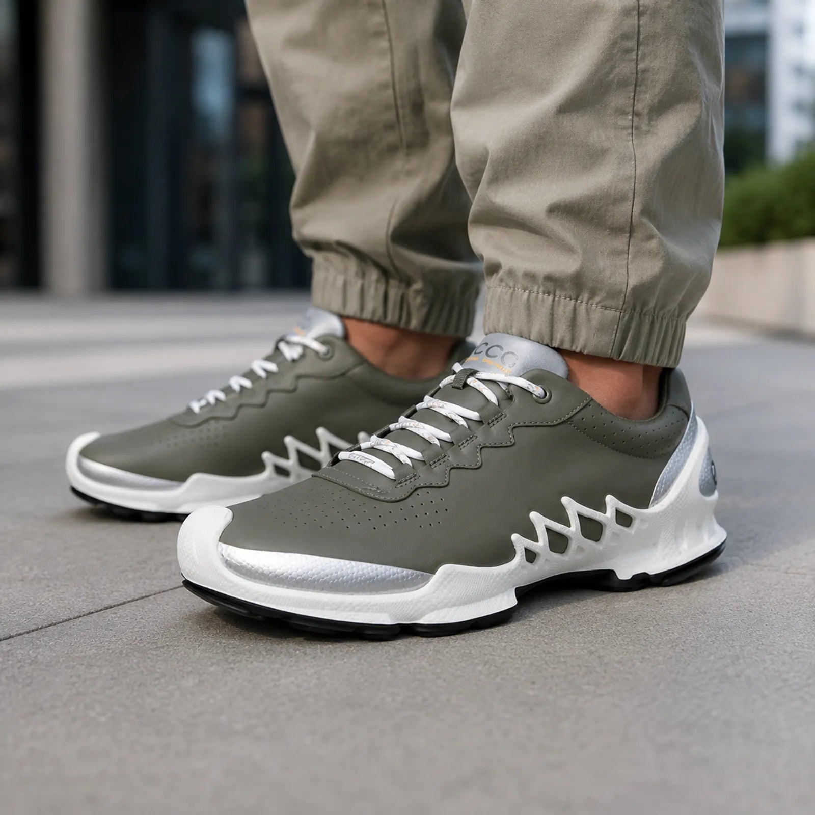 Close-up of men's olive-green lace-up sneakers with perforated toe