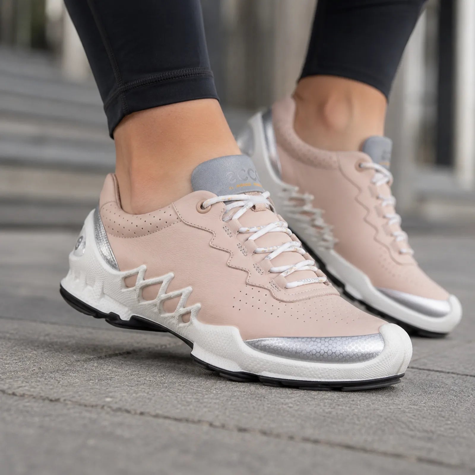 ECCO women's blush pink lace-up walking sneakers on feet with casual pants