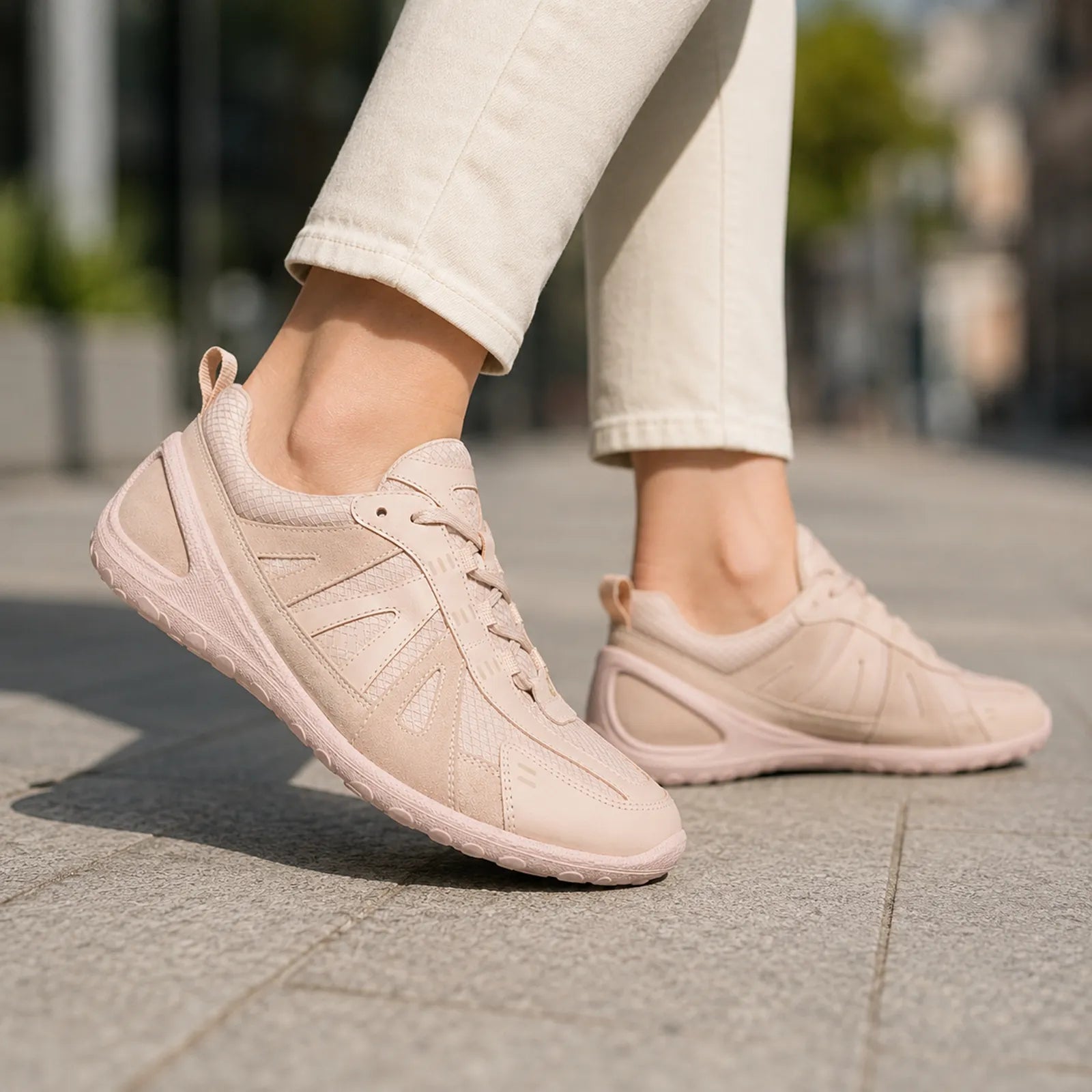 Women's pale pink lace-up sneaker worn with light pants and low-profile sole