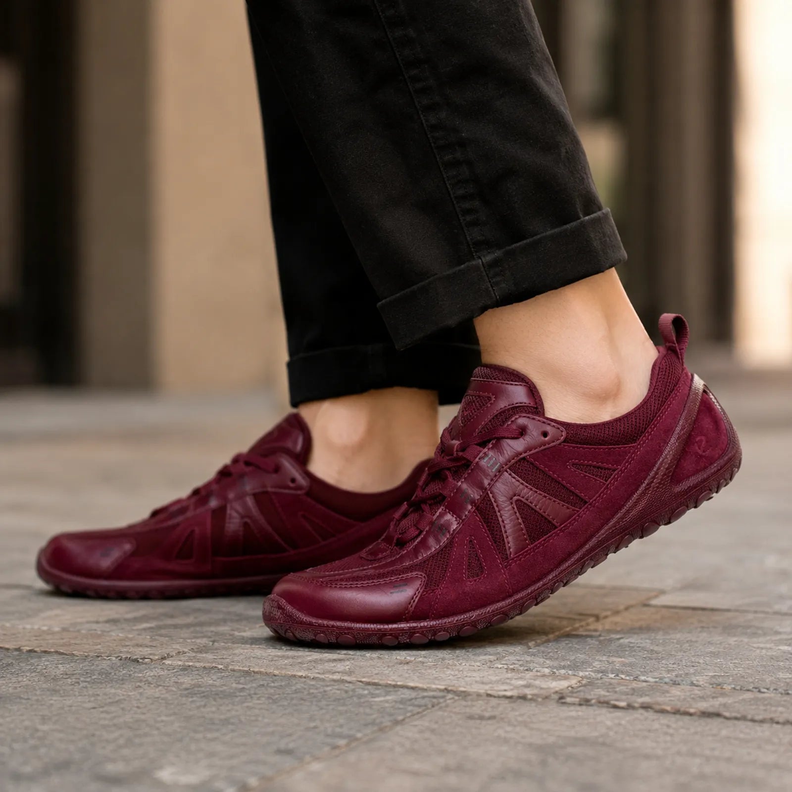 Women's dark red lace-up sneaker with cushioned sole on pavement