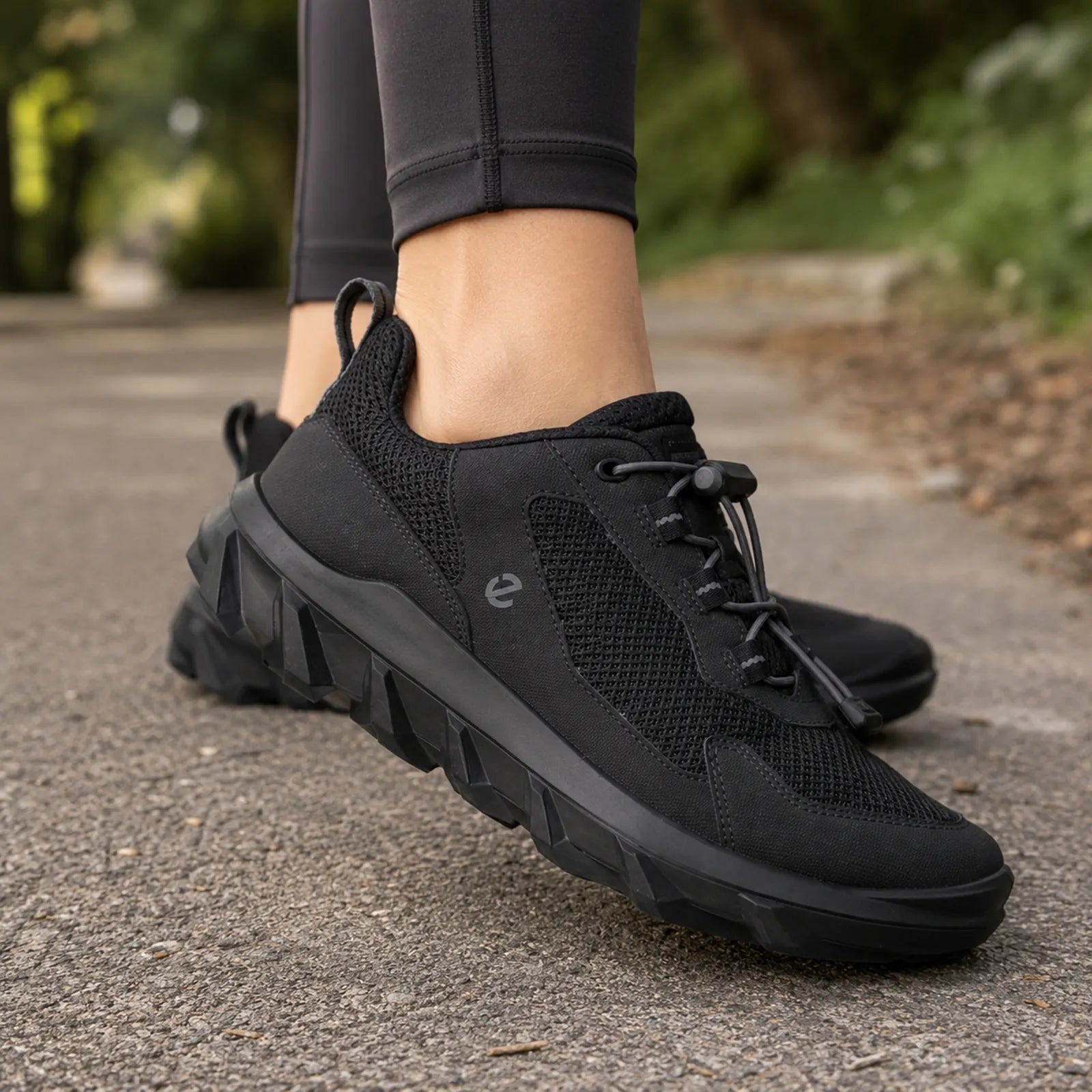 Black women's lace-up sneakers with textured mesh upper and thick outsole