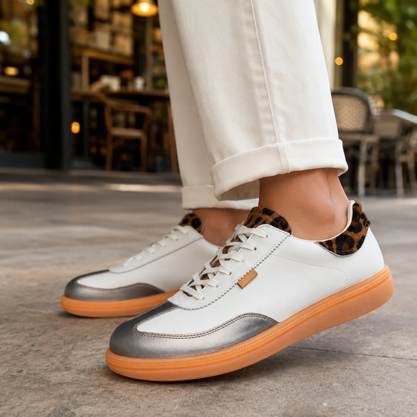 Women's white lace-up sneakers with gray side panels and orange rubber sole