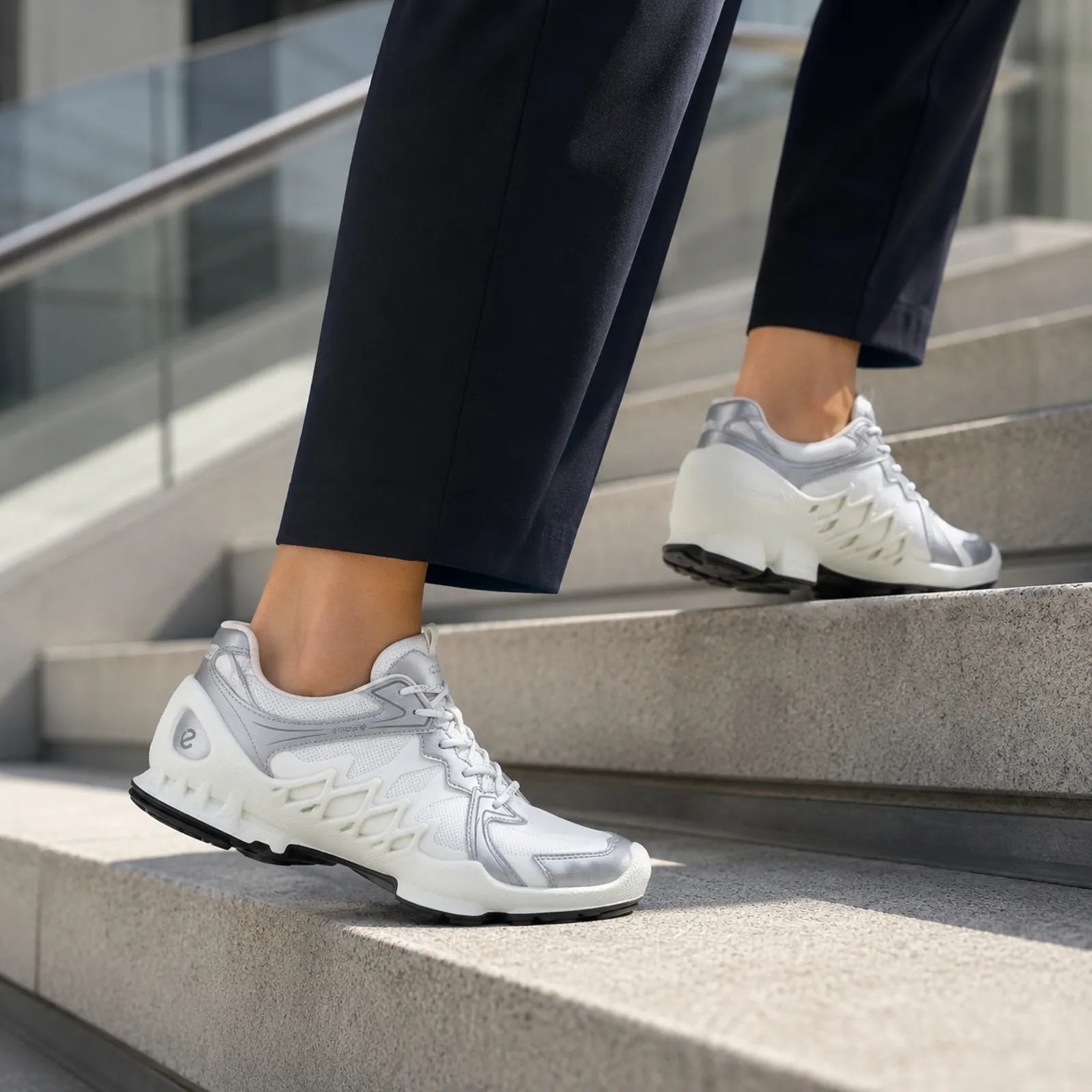 White lace-up sneakers on steps with chunky treaded rubber outsole
