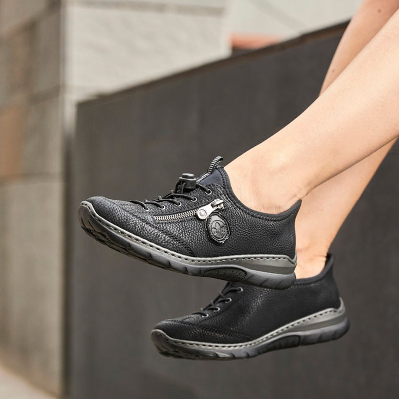 Women's black lace-up sneakers worn outdoors