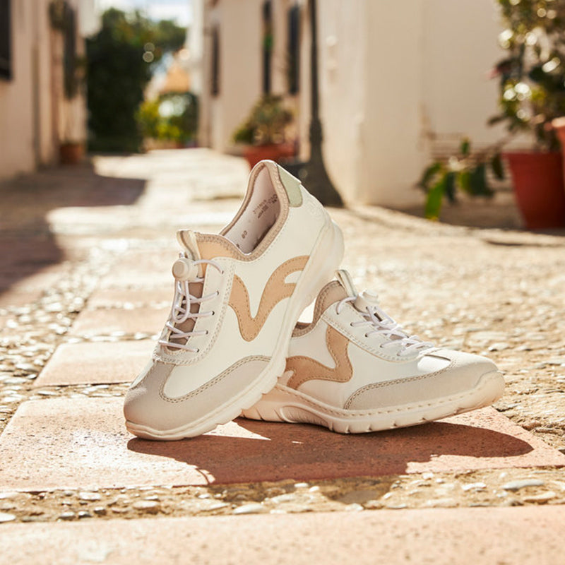 Cream sneakers with beige patterned panels and lace-up front