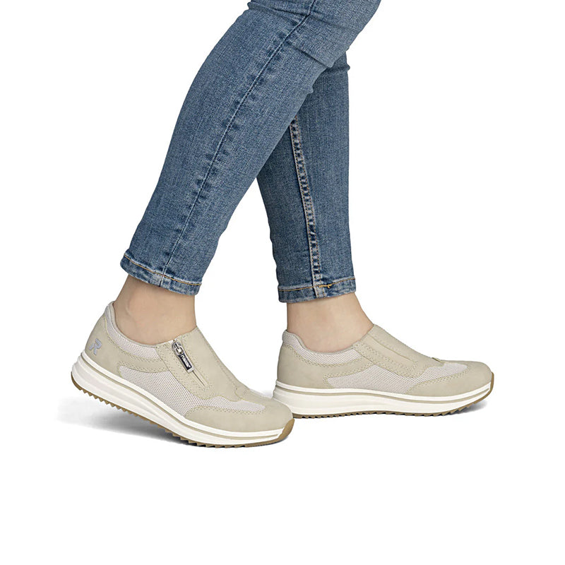Beige wide-fit walking sneakers on legs with side zip and textured sole