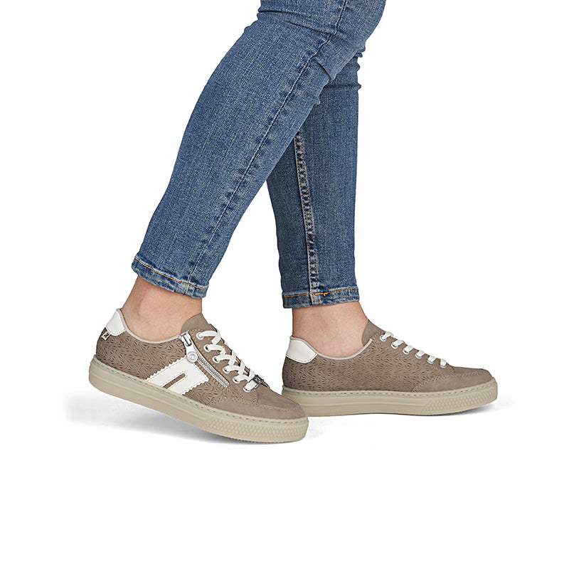 Brown low-top sneakers with lace-up worn with blue jeans
