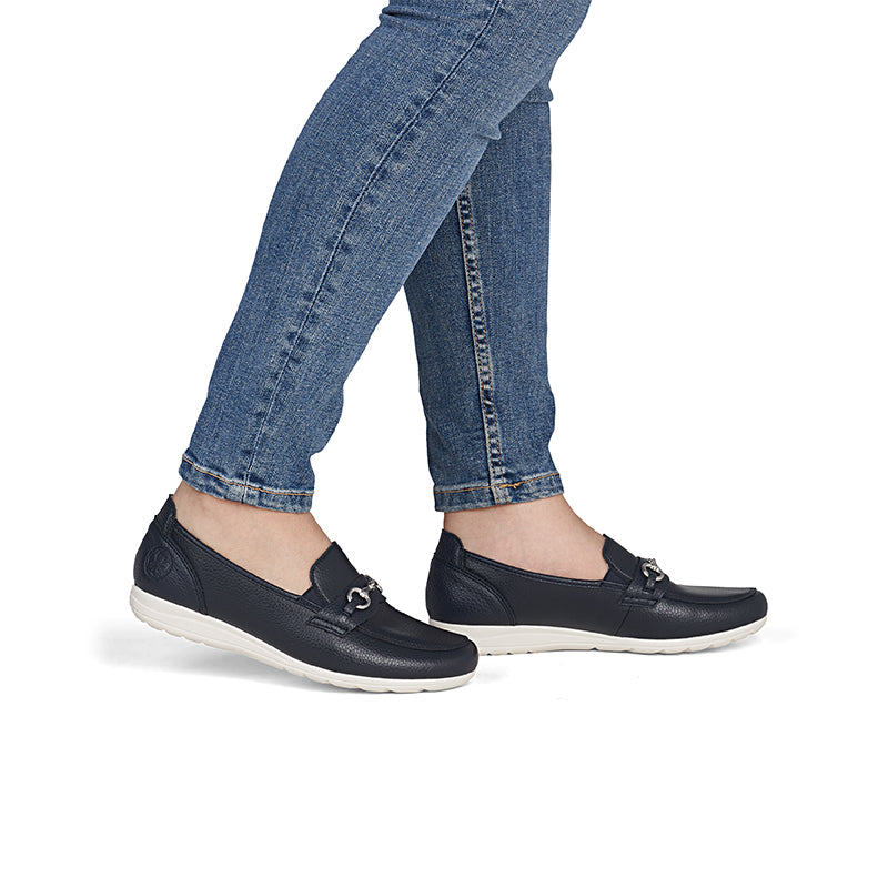 Women’s dark blue leather loafer shoes worn with blue jeans