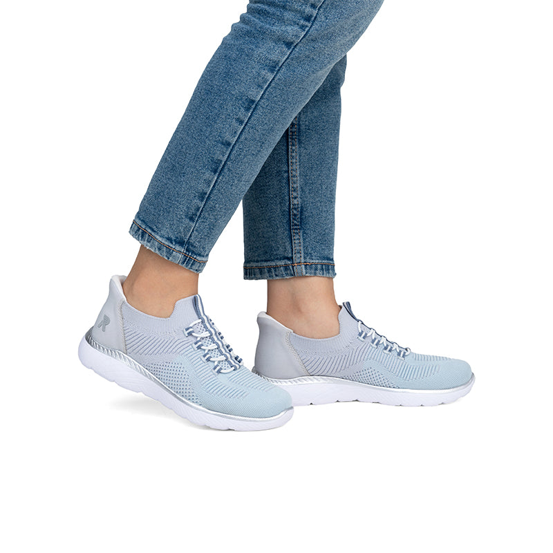 Light blue lace-up knit sneakers with white sole worn with blue jeans