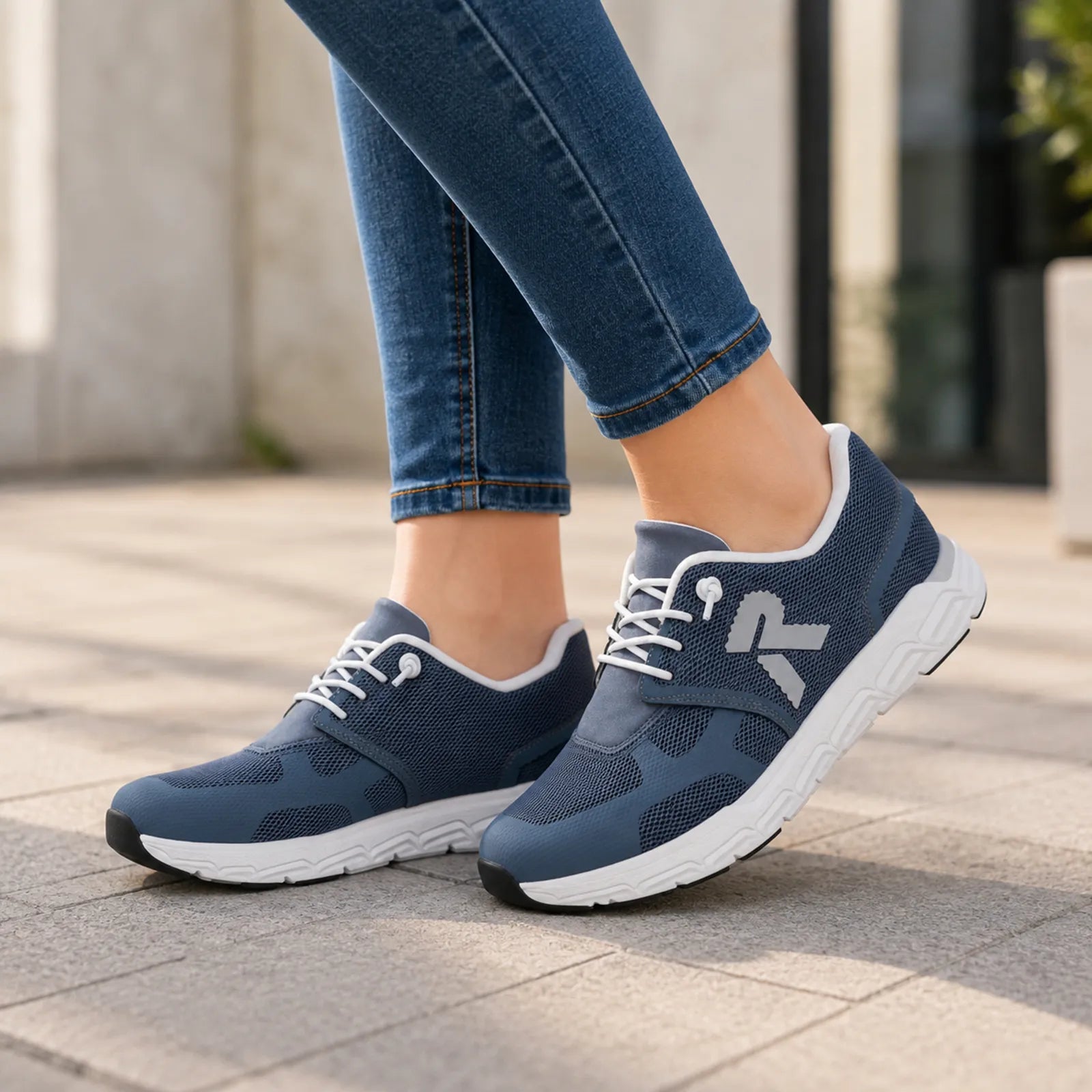 Women’s navy lace-up sneakers with white laces worn with blue jeans