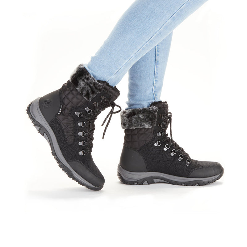 Black lace-up winter boots with faux fur trim worn with light blue jeans
