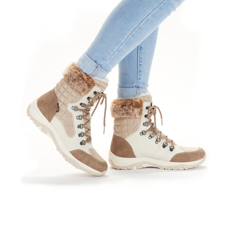 Beige lace-up winter boots with faux fur trim worn with light blue jeans