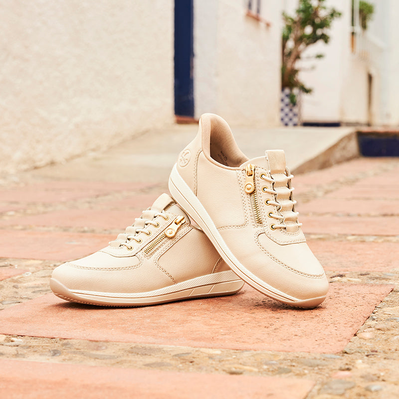 Beige lace-up sneakers with side zipper detail and cushioned low sole