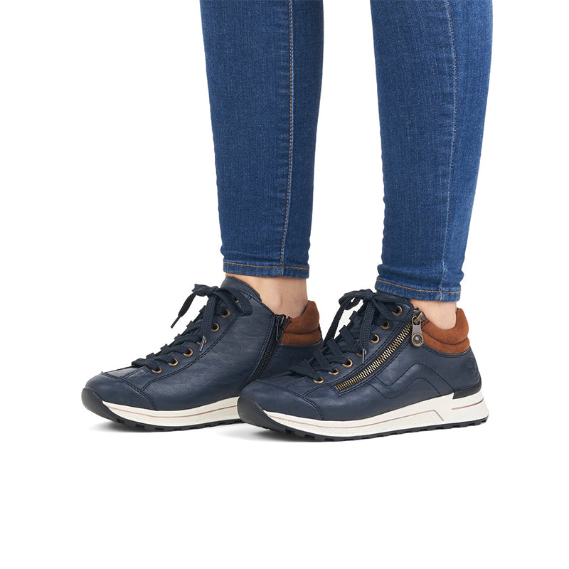 Rieker blue sneakers on feet with dark laces and side zip