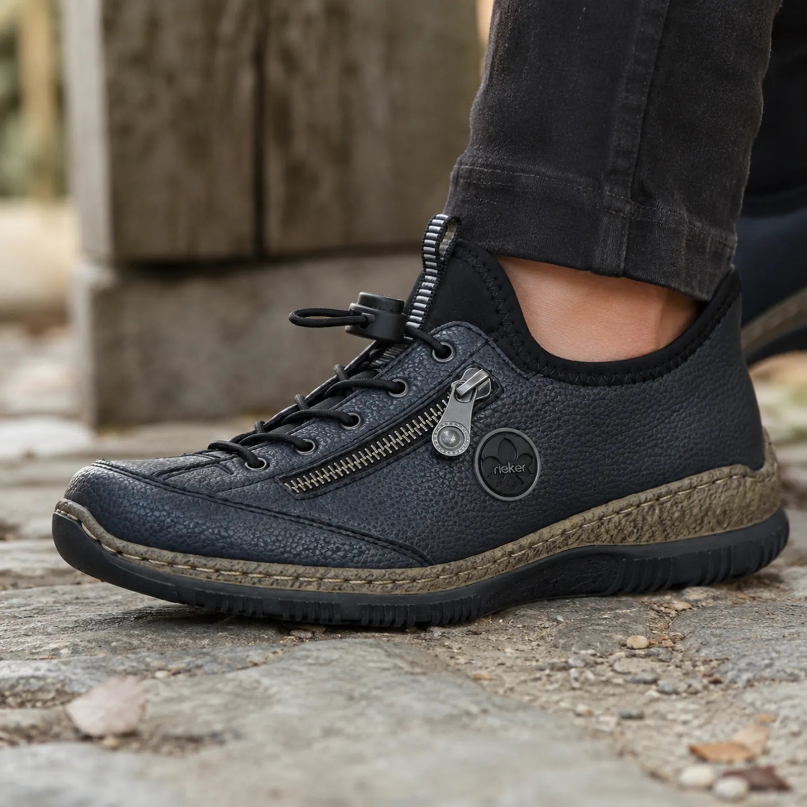Rieker women's dark sneaker with lace-up front, side zipper detail, and rugged sole