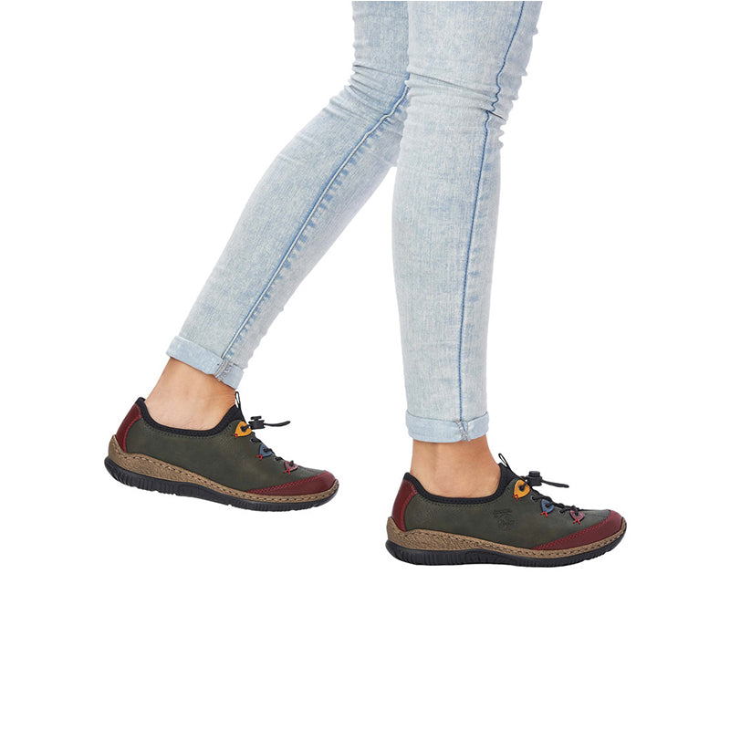 Women’s slip-on sneakers on model, dark gray upper with colorful laces and tan sole
