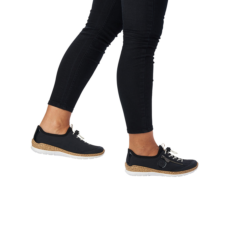Women's sneakers worn with black pants; dark navy upper and tan speckled sole