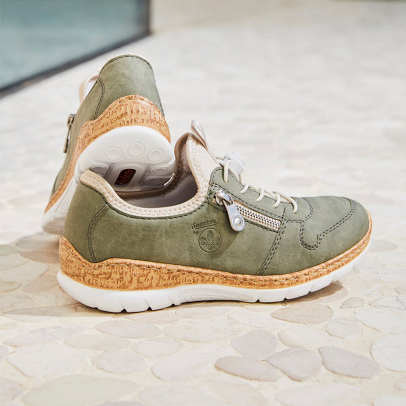 Olive green suede sneakers with lace-up front, cork-style midsole, and white sole