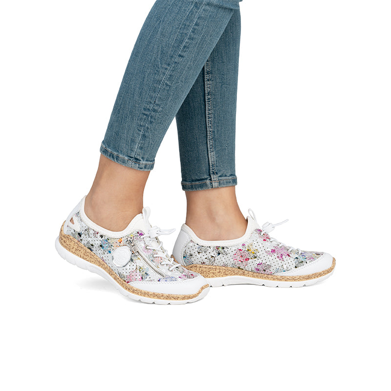 Multicolor knit lace-up sneakers with cushioned sole, worn with blue jeans.