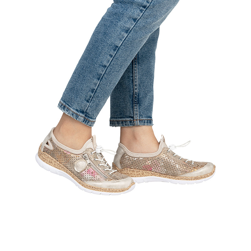 Multicolor knit sneakers with lace-up and beige textured sole, worn with jeans.