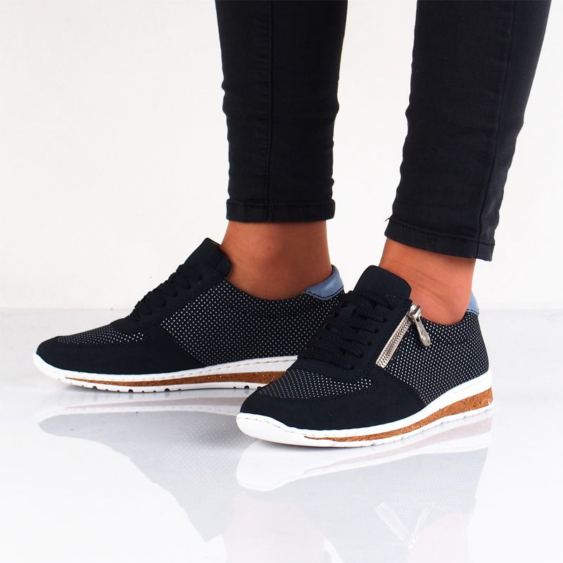 Navy lace-up sneakers with black laces worn with dark pants