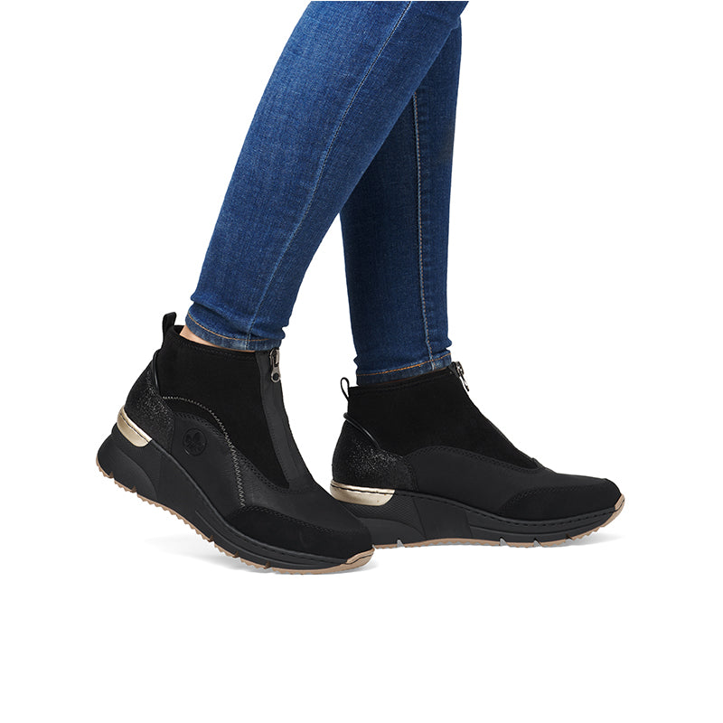 Women's black ankle boots with side zip, worn with blue jeans