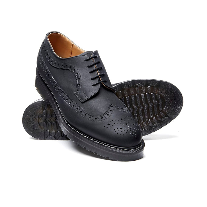 Black leather lace-up brogue shoes, showing treaded outsole and perforated panels