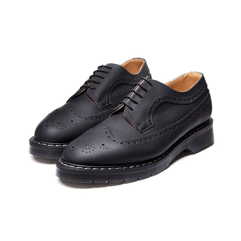 Black leather lace-up brogue shoes with wingtip styling and chunky platform sole