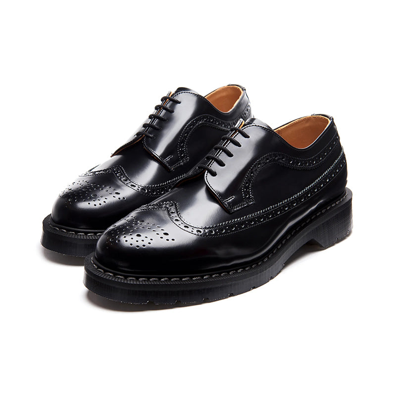 Black leather brogue lace-up shoes, front angle with wingtip panels and laces