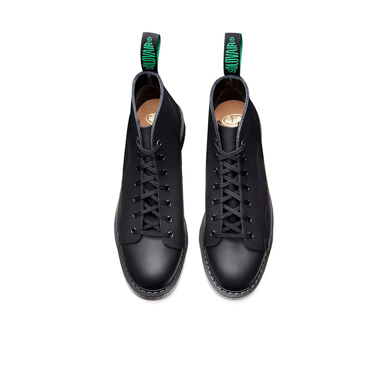 Pair of black lace-up monkey boots with green pull tabs, front view.