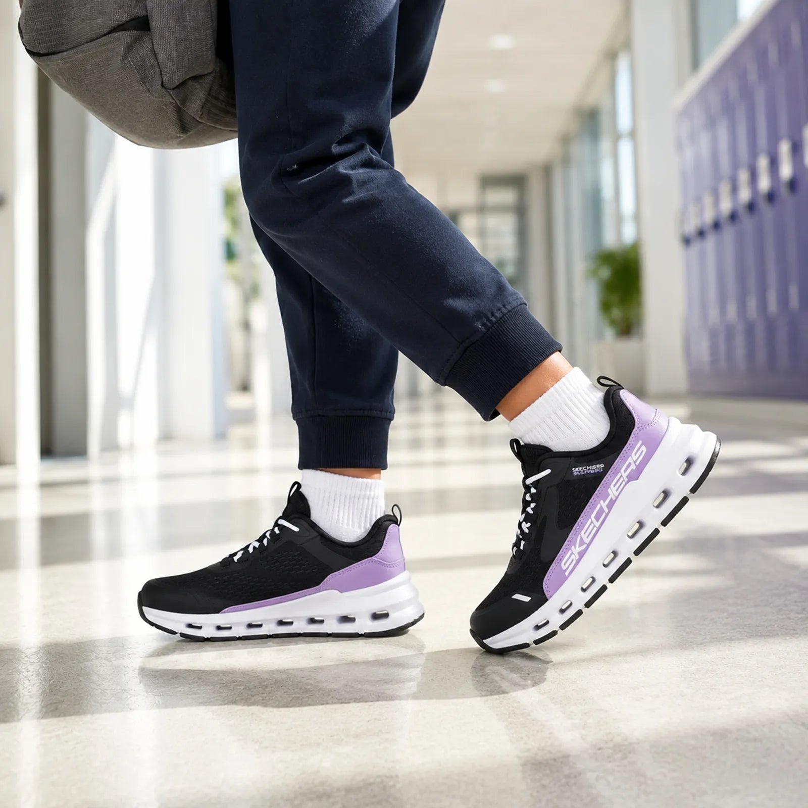 Girls' lace-up sneakers with black upper, purple trim, and white treaded sole