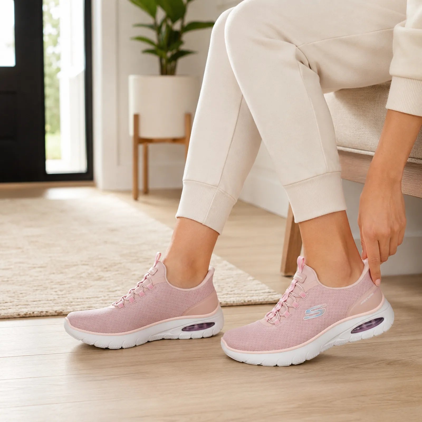 Pair of pink Skechers slip-on sneakers with lace-up front and cushioned sole