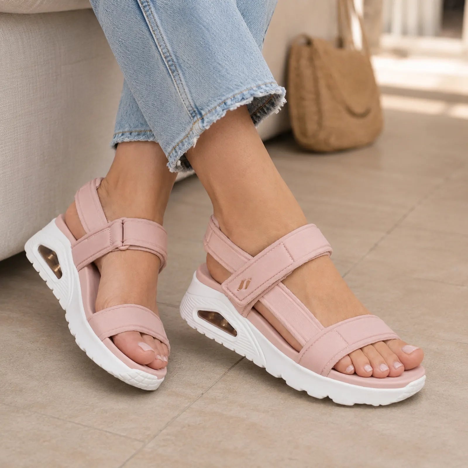 Pink sport sandals with hook-and-loop straps and cushioned white sole on feet
