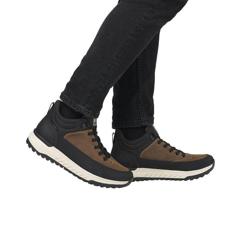 Men's lace-up boots worn with dark jeans; brown uppers, black panels, cream sole