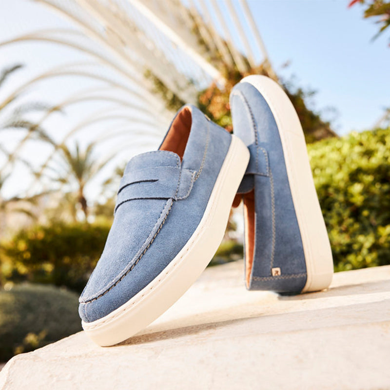 Blue suede slip-on loafers with bow strap and cushioned collar