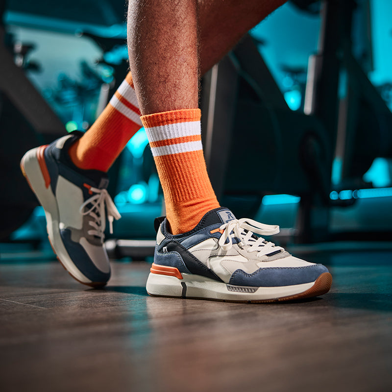Rieker men's trainers with blue and white panels, worn with orange crew socks
