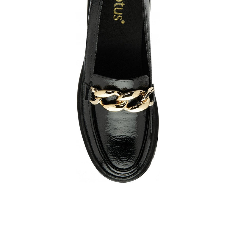 Close-up of black patent loafer with gold chain accent across the vamp