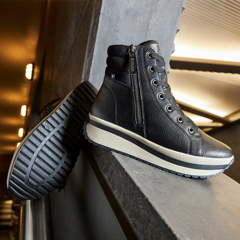 Black winter boot with lace-up ties, side zipper, and white midsole stripe